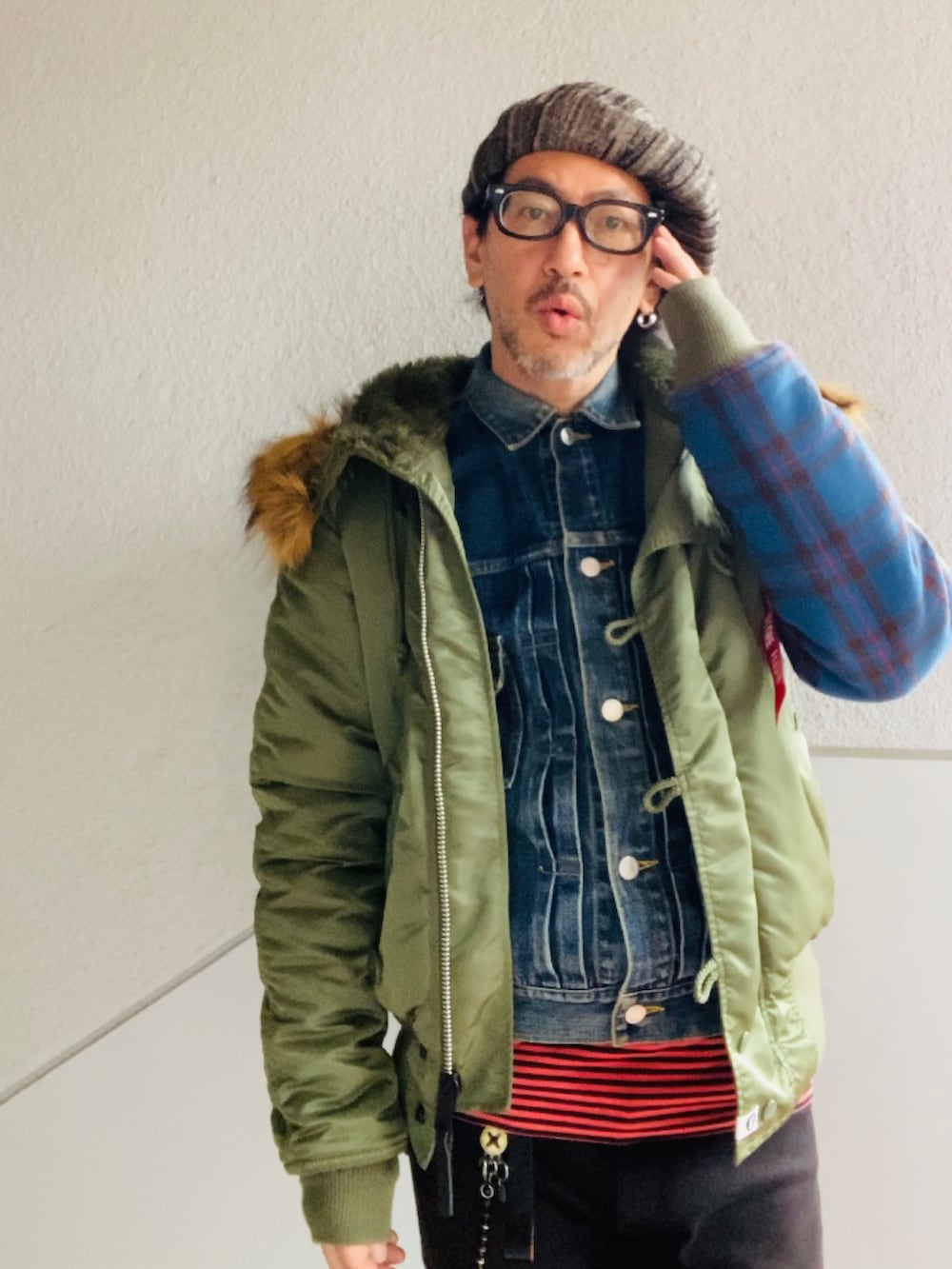 グリーン系のMA-1、ブルー系のデニムジャケット、ブラック系のパンツを着用したメンズの冬コーディネートの2枚目の写真