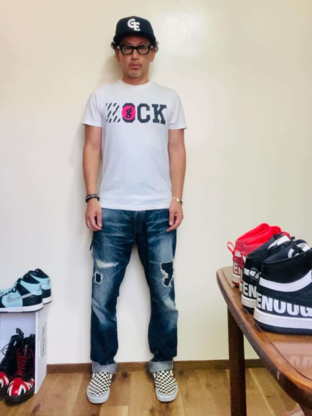 ホワイト系のスリッポン、ホワイト系のTシャツ/カットソー、ブルー系のデニムパンツを着用したメンズの夏コーディネートの3枚目の写真