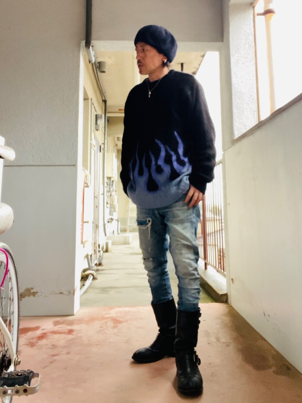 ブラック系のニット/セーター、ブルー系のデニムパンツ、ブラック系のブーツを着用したメンズの冬コーディネートの5枚目の写真
