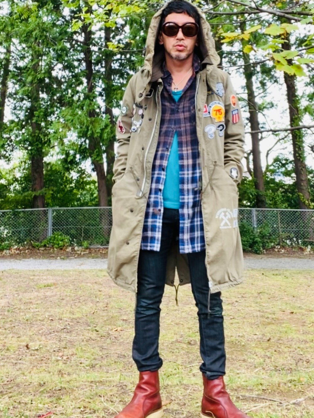 グリーン系のモッズコート、ブルー系のシャツ/ブラウス、ブラック系のデニムパンツを着用したメンズの秋コーディネートの5枚目の写真