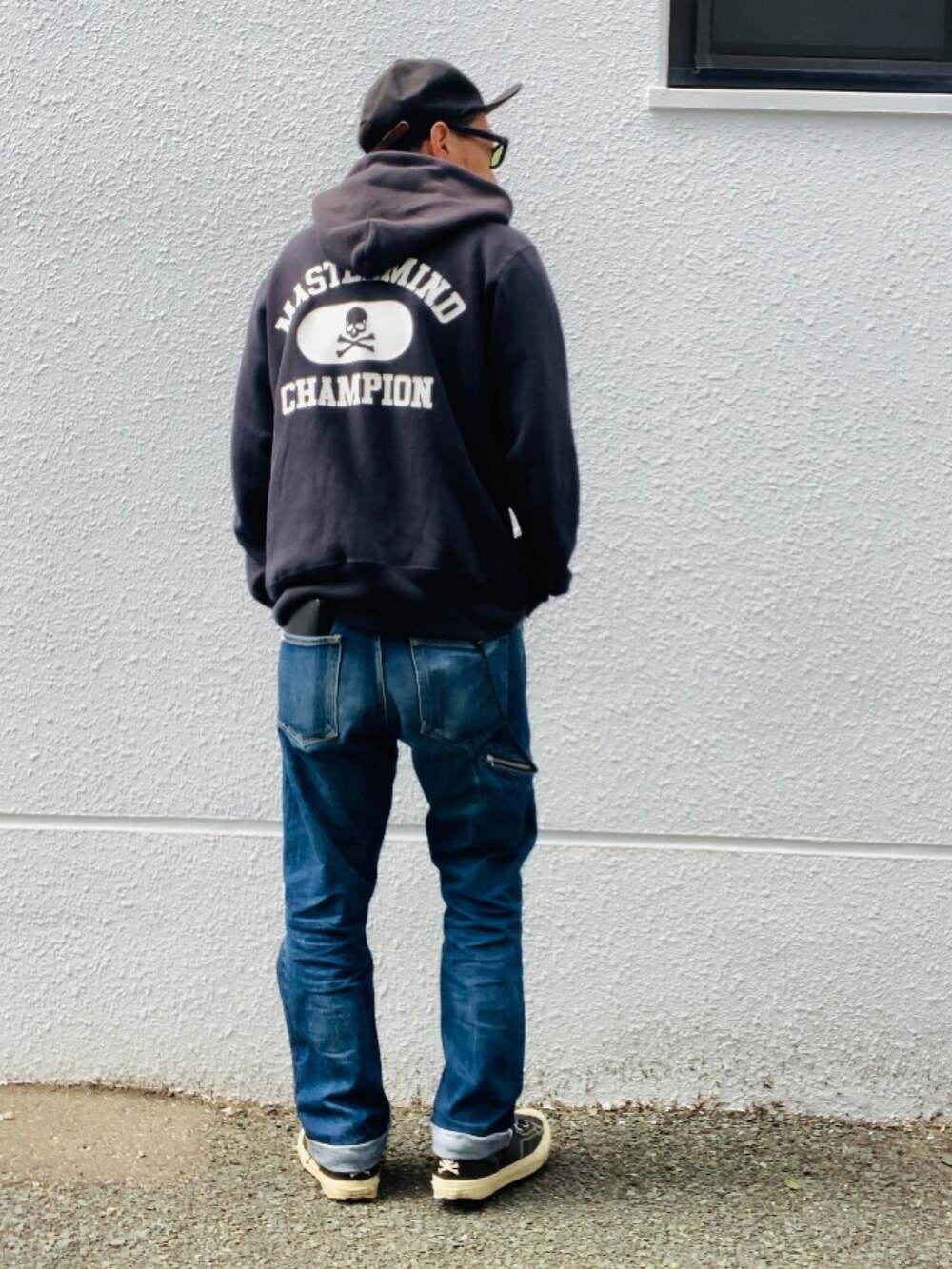 ブラック系のパーカー、ブルー系のデニムパンツ、ブラック系のスニーカーを着用したメンズの春コーディネートの2枚目の写真