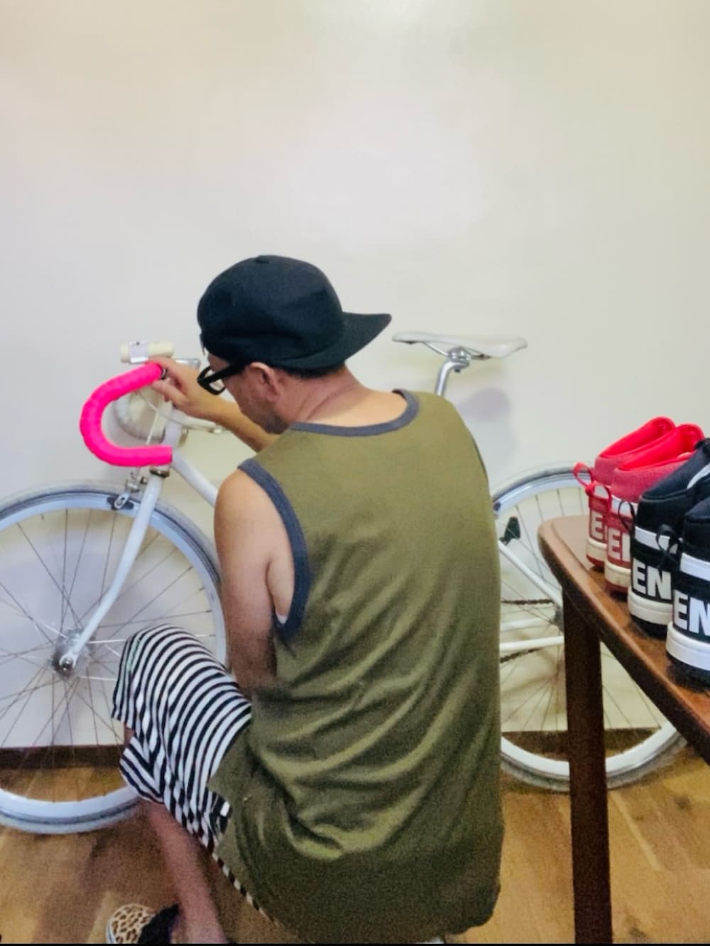 グリーン系のタンクトップ、グレー系のスウェットパンツ、ベージュ系のスニーカーを着用したメンズの夏コーディネートの2枚目の写真