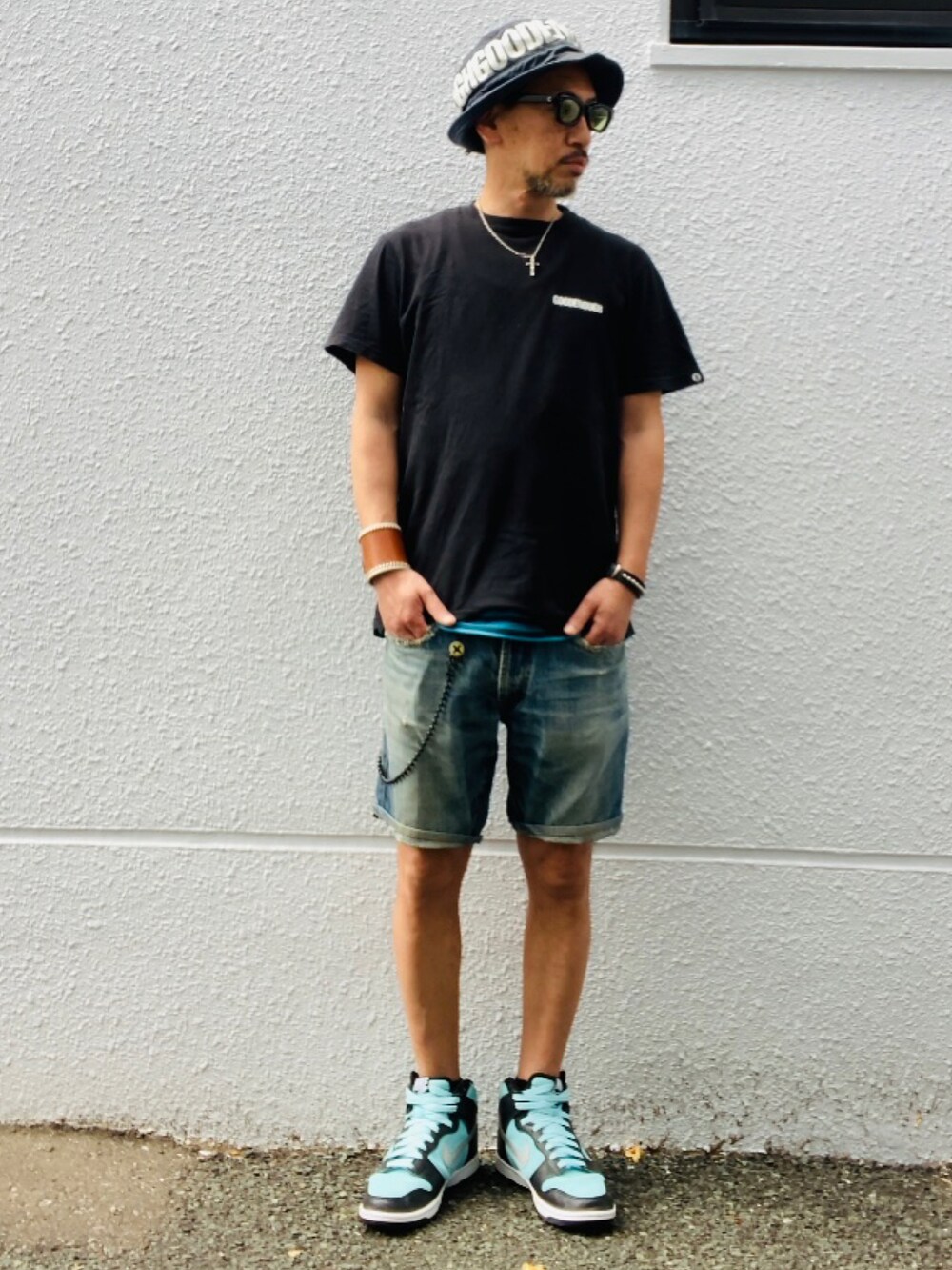 ブラック系のTシャツ/カットソー、ブルー系のその他パンツ、グリーン系のスニーカーを着用したメンズの夏コーディネートの3枚目の写真