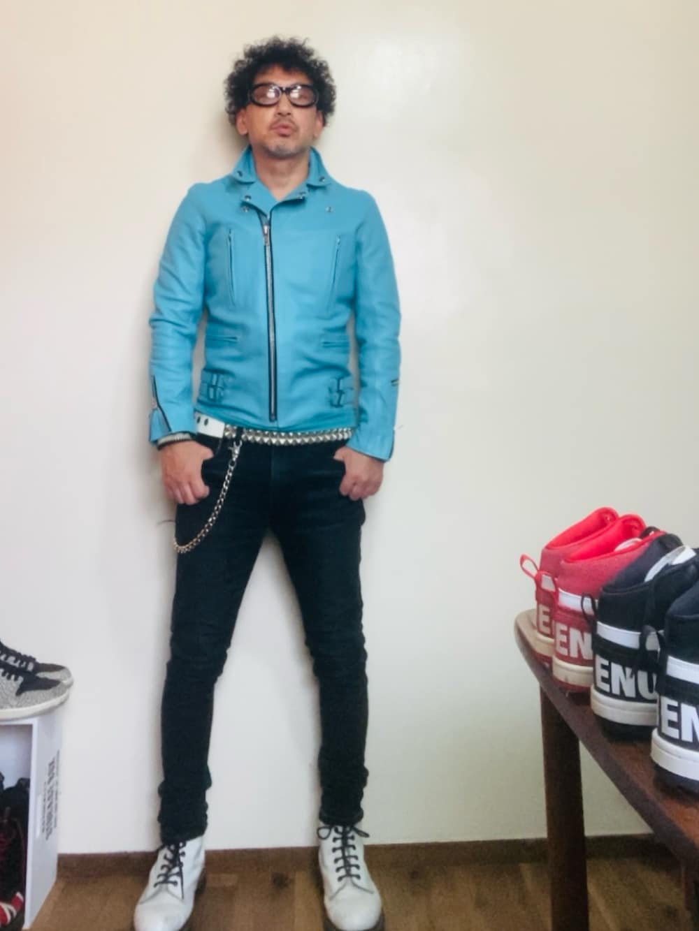 ブルー系のライダースジャケット、ブラック系のデニムパンツ、ホワイト系のブーツを着用したメンズの秋コーディネートの4枚目の写真