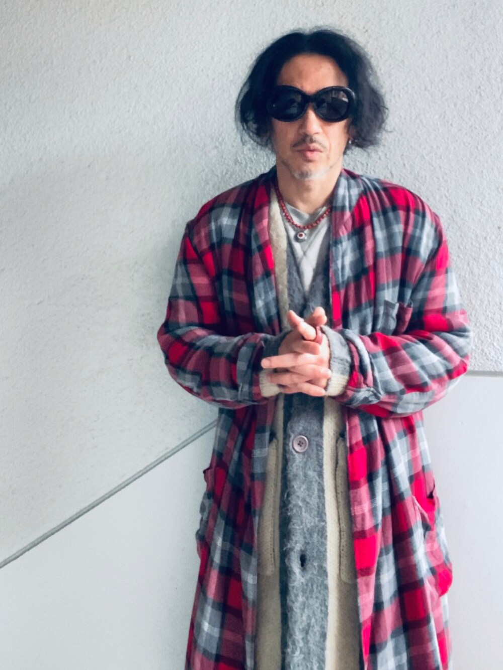 グレー系のカーディガン/ボレロ、レッド系のノーカラーコート、ブラック系のパンツを着用したメンズの冬コーディネートの2枚目の写真