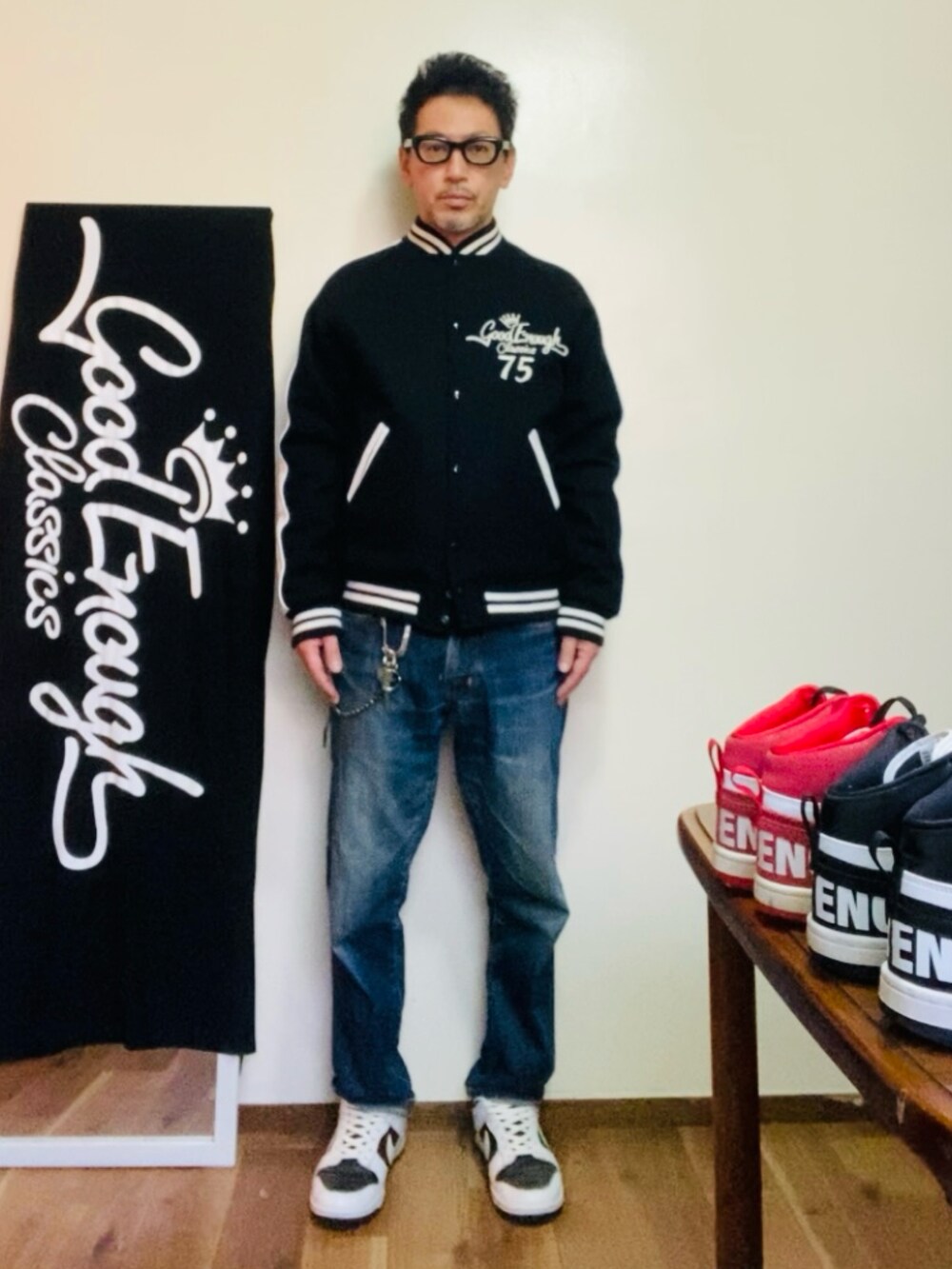 ブラック系のスタジャン、ブルー系のデニムパンツ、ホワイト系のスニーカーを着用したメンズの冬コーディネートの3枚目の写真