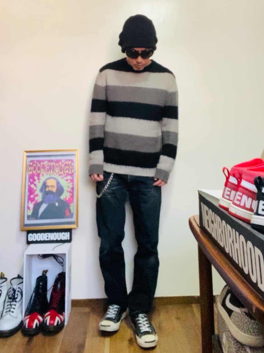 ブラック系のニット/セーター、ブラック系のデニムパンツ、ブラック系のスニーカーを着用したメンズの春コーディネートの5枚目の写真