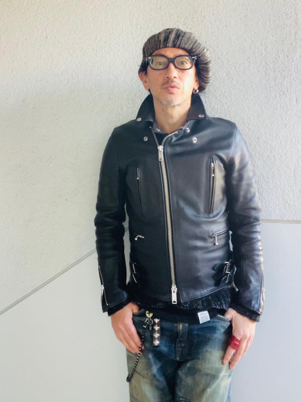 ブルー系のデニムパンツ、ブラック系のライダースジャケット、ブラック系のニット/セーターを着用したメンズの冬コーディネートの3枚目の写真