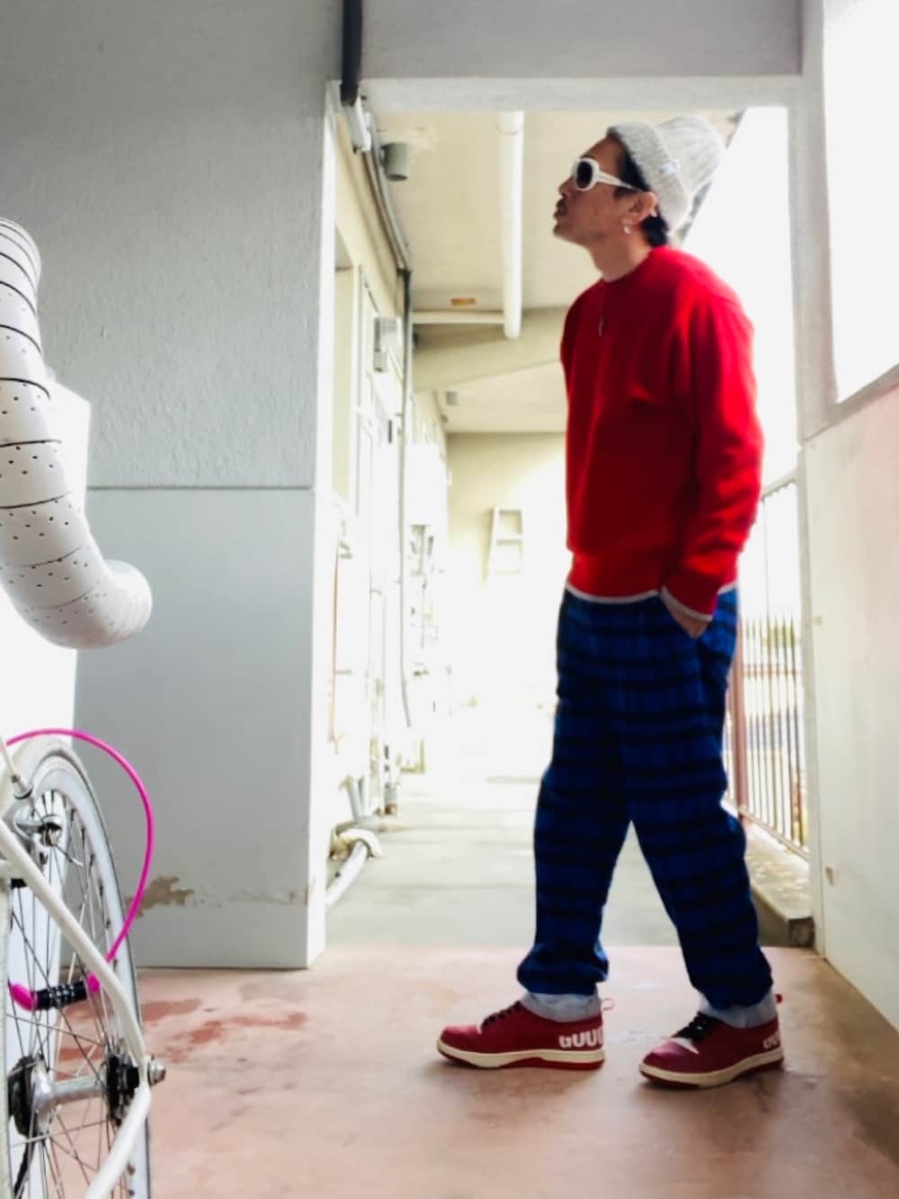 ブルー系のその他パンツ、レッド系のニット/セーター、レッド系のスニーカーを着用したメンズの秋コーディネートの5枚目の写真