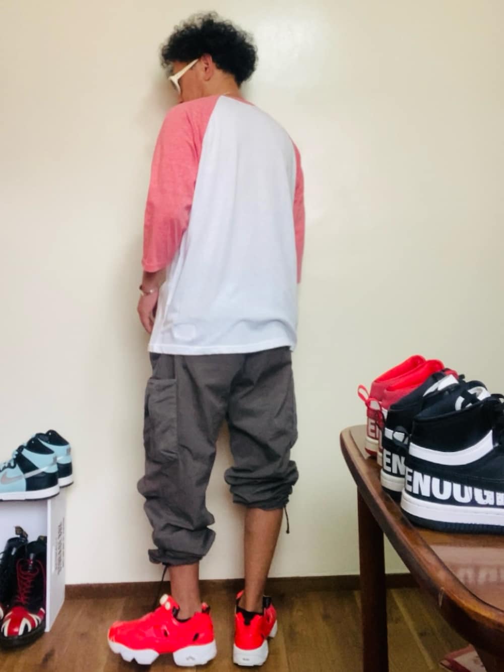 ピンク系のTシャツ/カットソー、グレー系のカーゴパンツ、ピンク系のスニーカーを着用したメンズの夏コーディネートの2枚目の写真