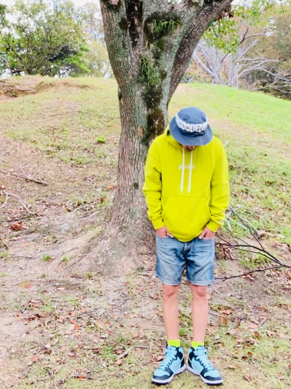 イエロー系のパーカー、ブルー系のその他パンツ、グリーン系のスニーカーを着用したメンズの秋コーディネートの5枚目の写真