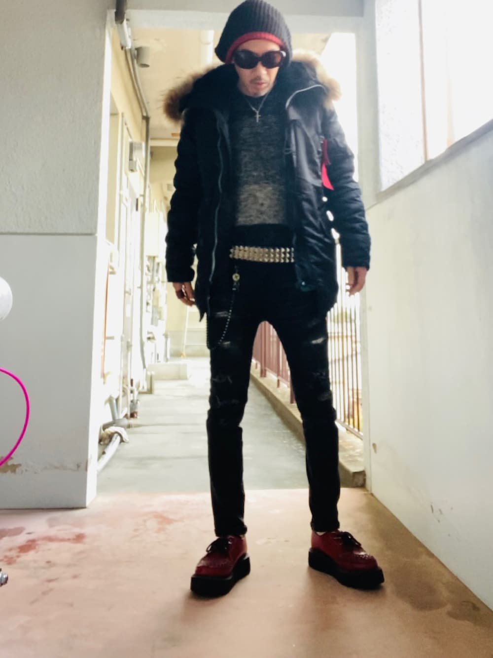 ブラック系のミリタリージャケット、ブラック系のニット/セーター、ブラック系のデニムパンツを着用したメンズの冬コーディネートの3枚目の写真