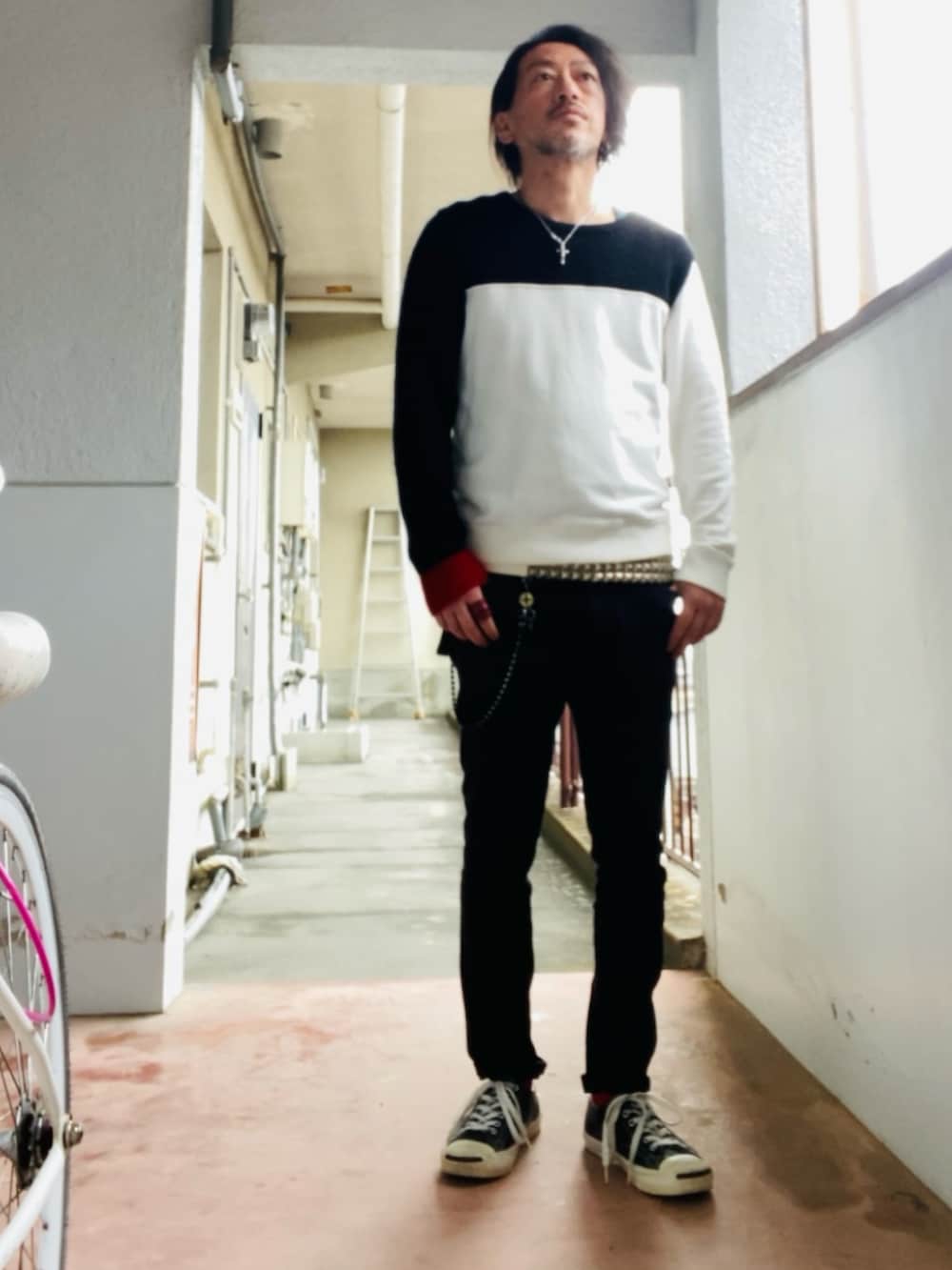 ブラック系のニット/セーター、ブラック系のパンツ、ブラック系のスニーカーを着用したメンズの春コーディネートの4枚目の写真