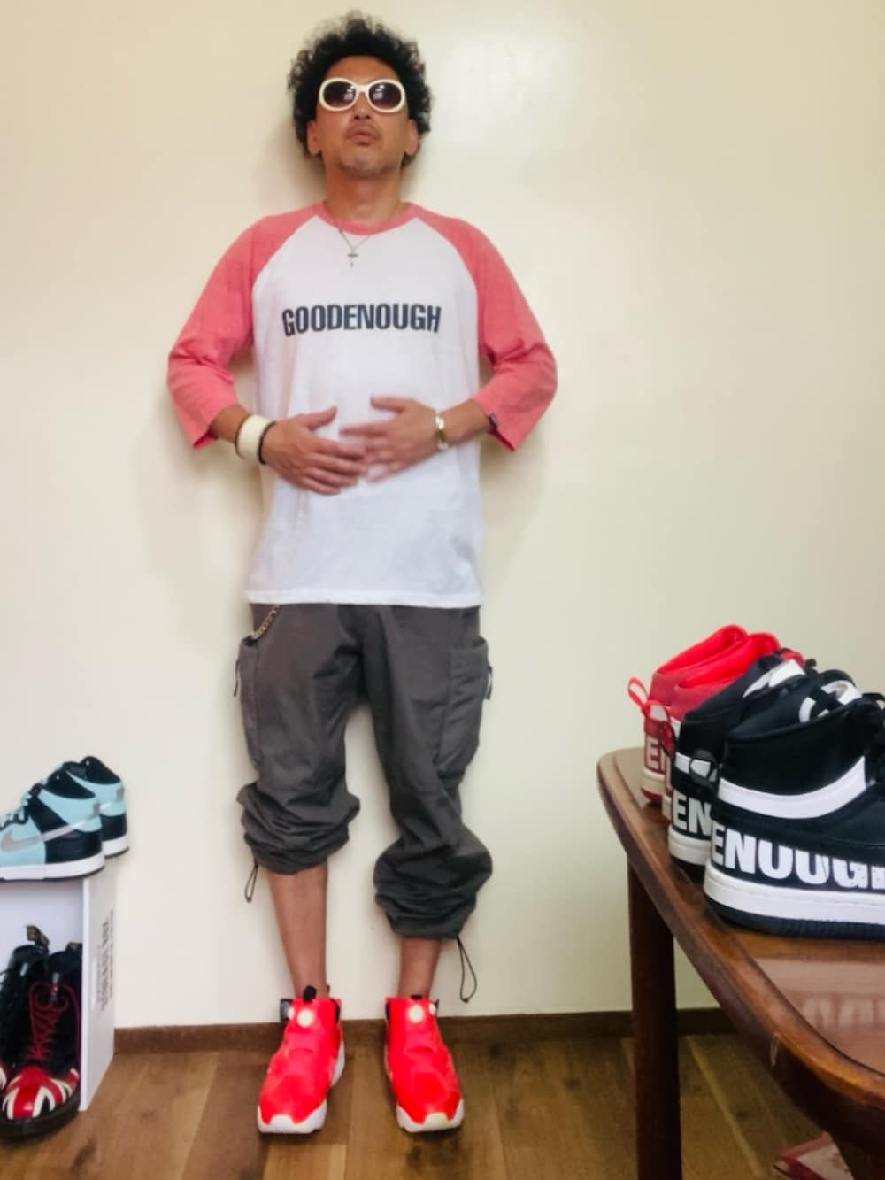 ピンク系のTシャツ/カットソー、グレー系のカーゴパンツ、ピンク系のスニーカーを着用したメンズの夏コーディネートの3枚目の写真