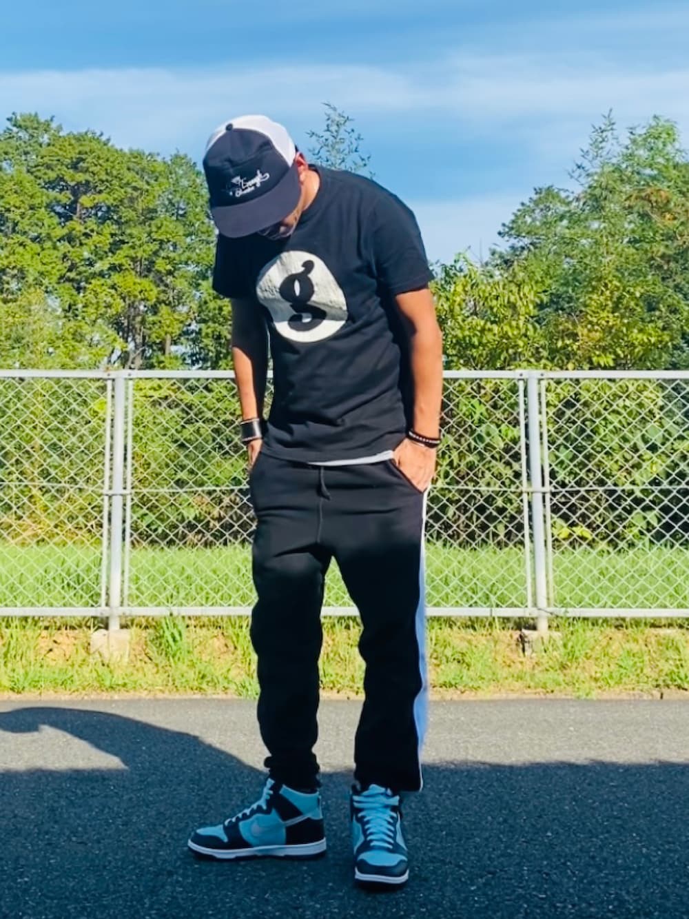 ブラック系のTシャツ/カットソー、ブラック系のスウェットパンツ、グリーン系のスニーカーを着用したメンズの秋コーディネートの5枚目の写真