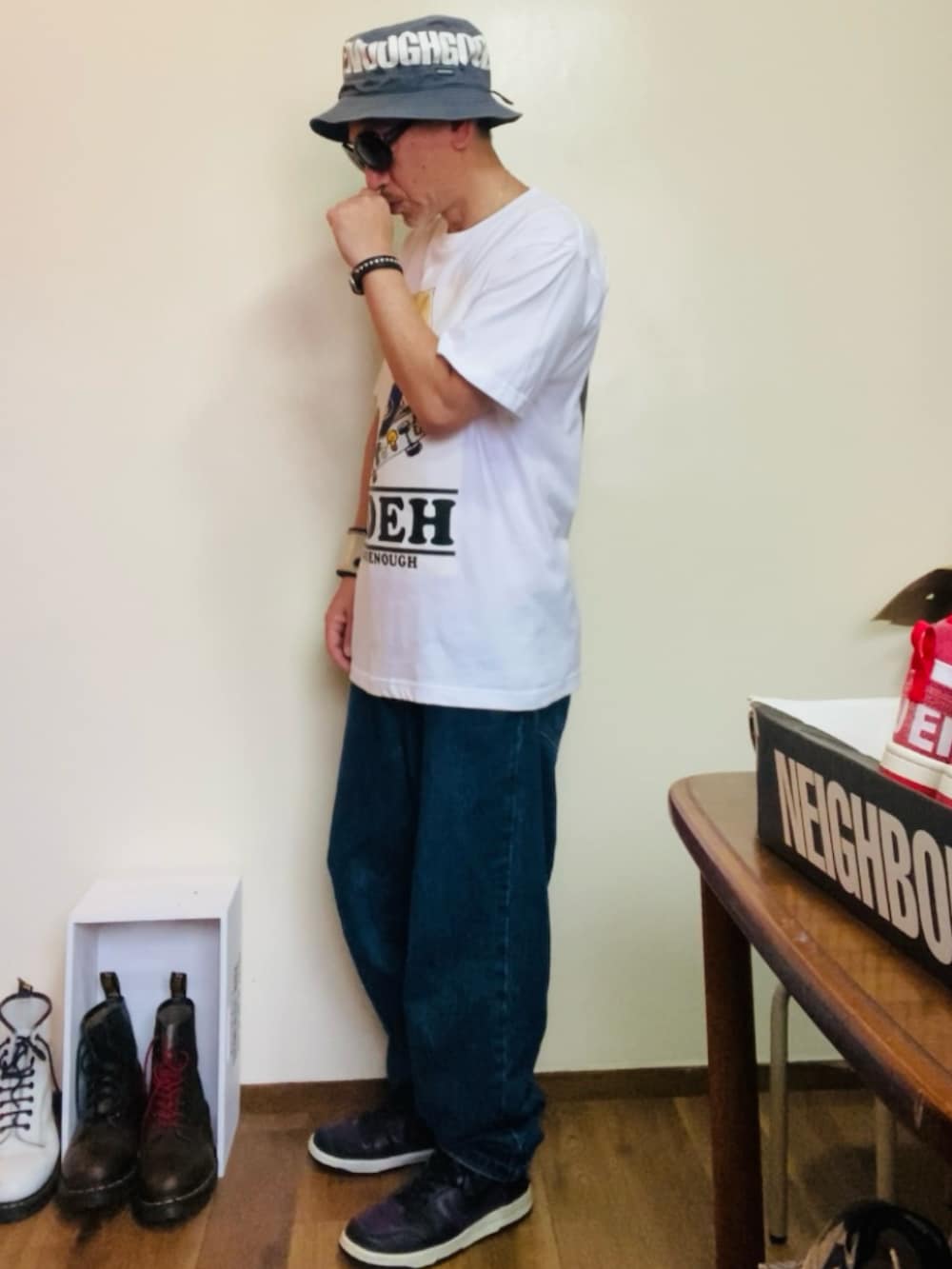 ブルー系のデニムパンツ、パープル系のスニーカー、ブルー系のハットを着用したメンズの夏コーディネートの2枚目の写真