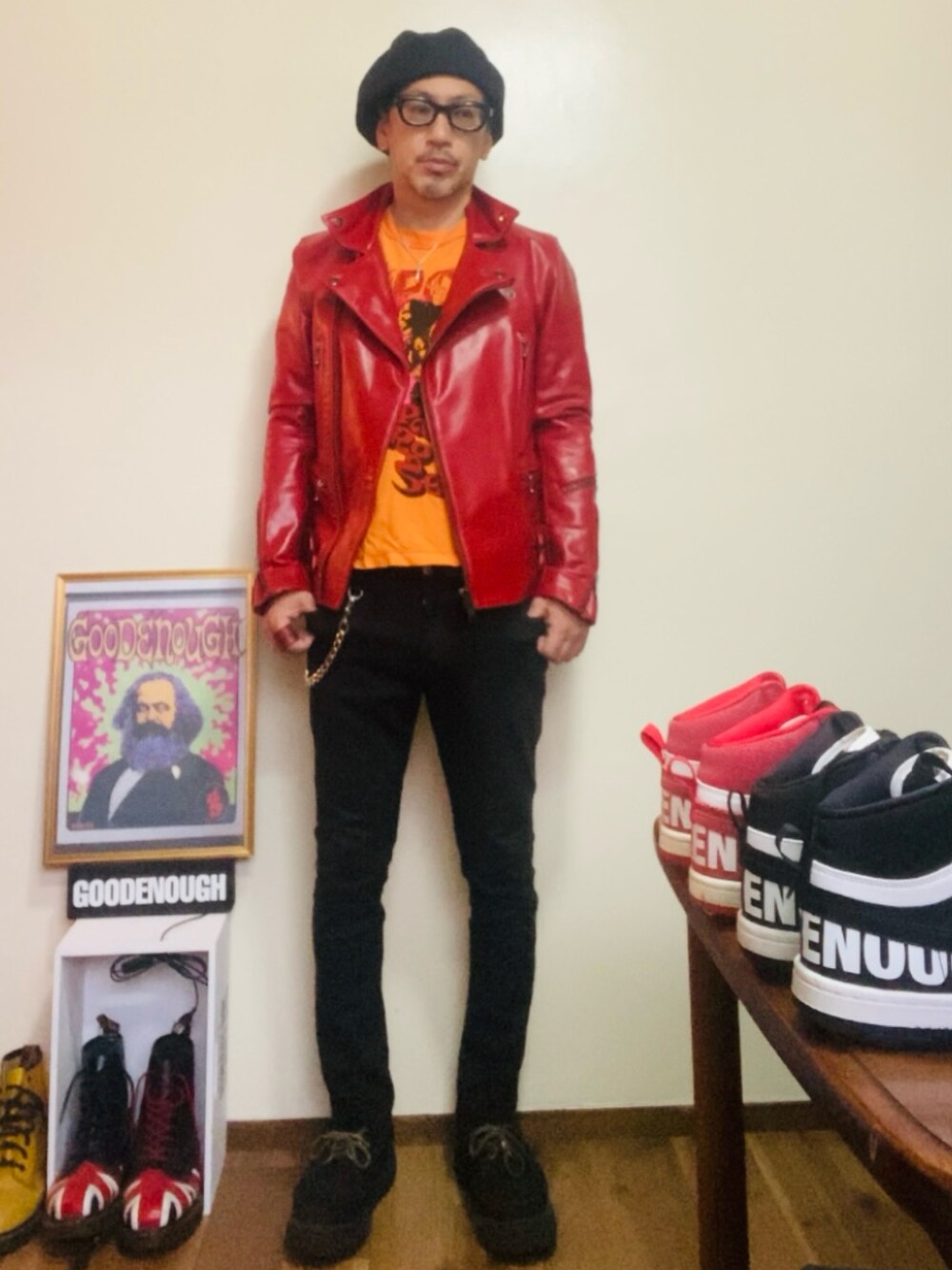 レッド系のライダースジャケット、オレンジ系のTシャツ/カットソー、ブラック系のパンツを着用したメンズの秋コーディネートの3枚目の写真