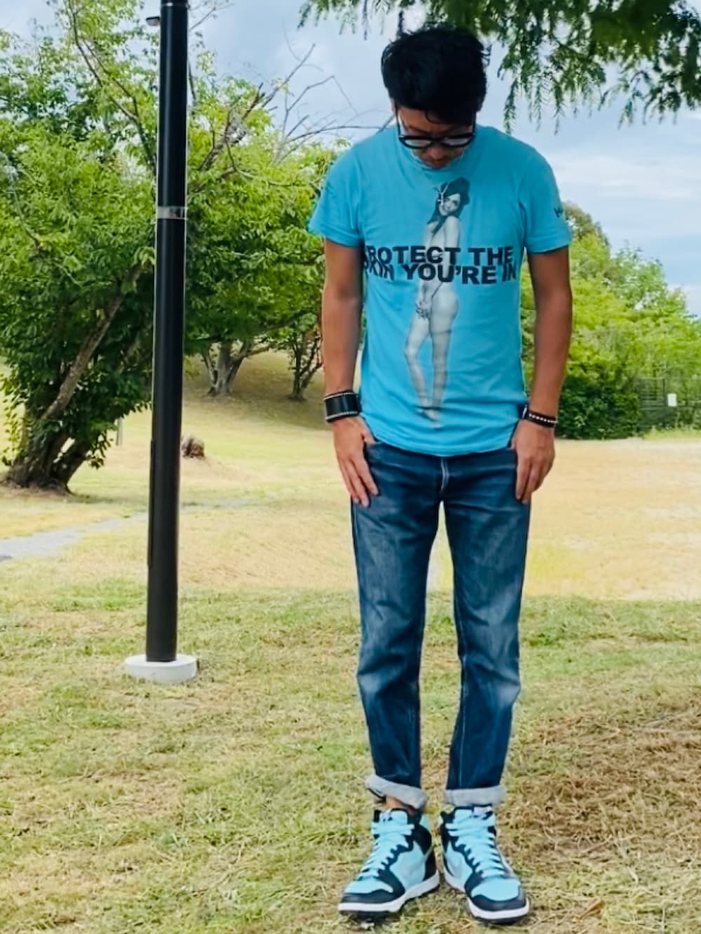 ブルー系のTシャツ/カットソー、ブルー系のデニムパンツ、グリーン系のスニーカーを着用したメンズの夏コーディネートの4枚目の写真