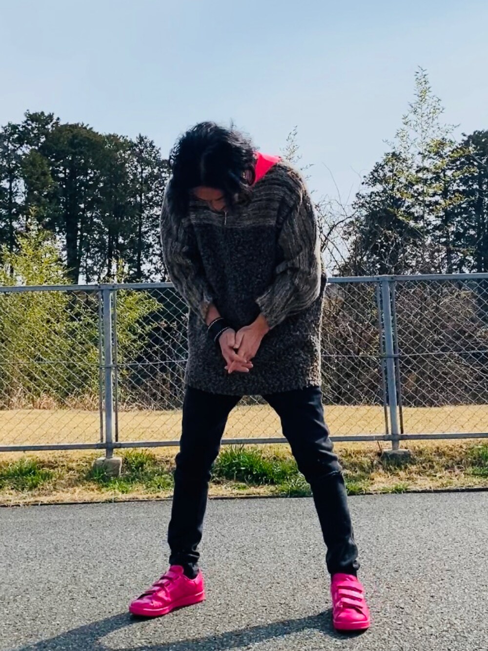 ブラウン系のニット/セーター、ピンク系のTシャツ/カットソー、ブラック系のデニムパンツを着用したメンズの春コーディネートの5枚目の写真