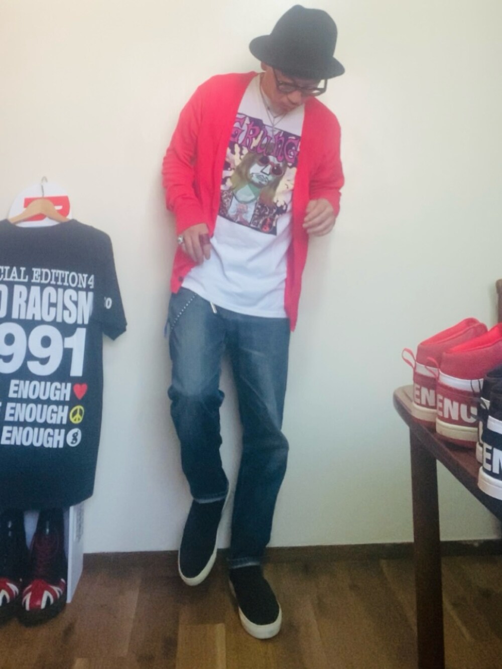 ピンク系のカーディガン/ボレロ、ホワイト系のTシャツ/カットソー、ブルー系のデニムパンツを着用したメンズの秋コーディネートの4枚目の写真