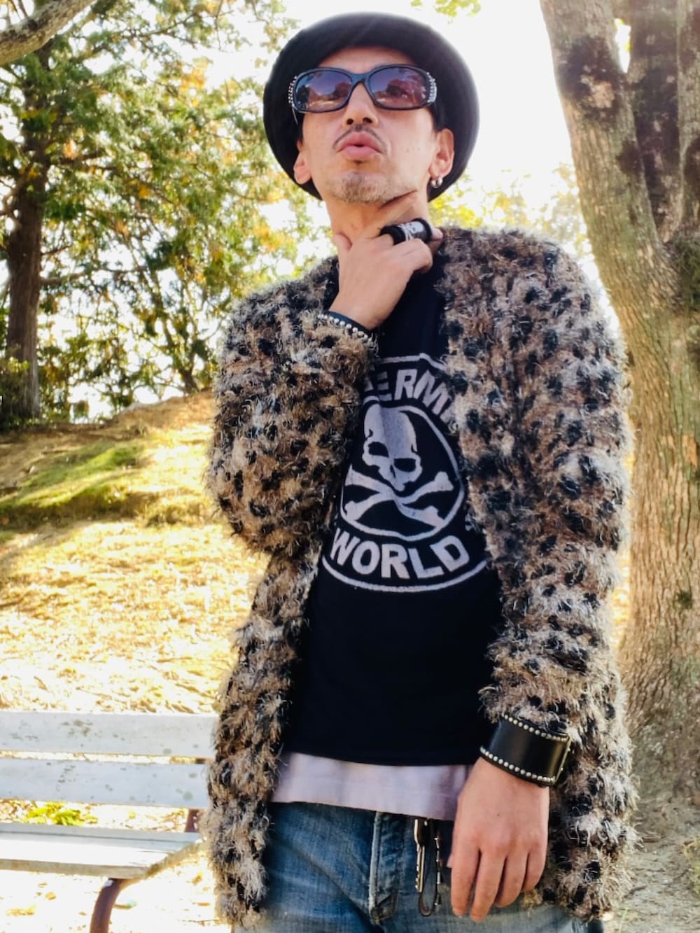 ブラウン系のカーディガン/ボレロ、ブラック系のTシャツ/カットソー、ブルー系のデニムパンツを着用したメンズの秋コーディネートの2枚目の写真