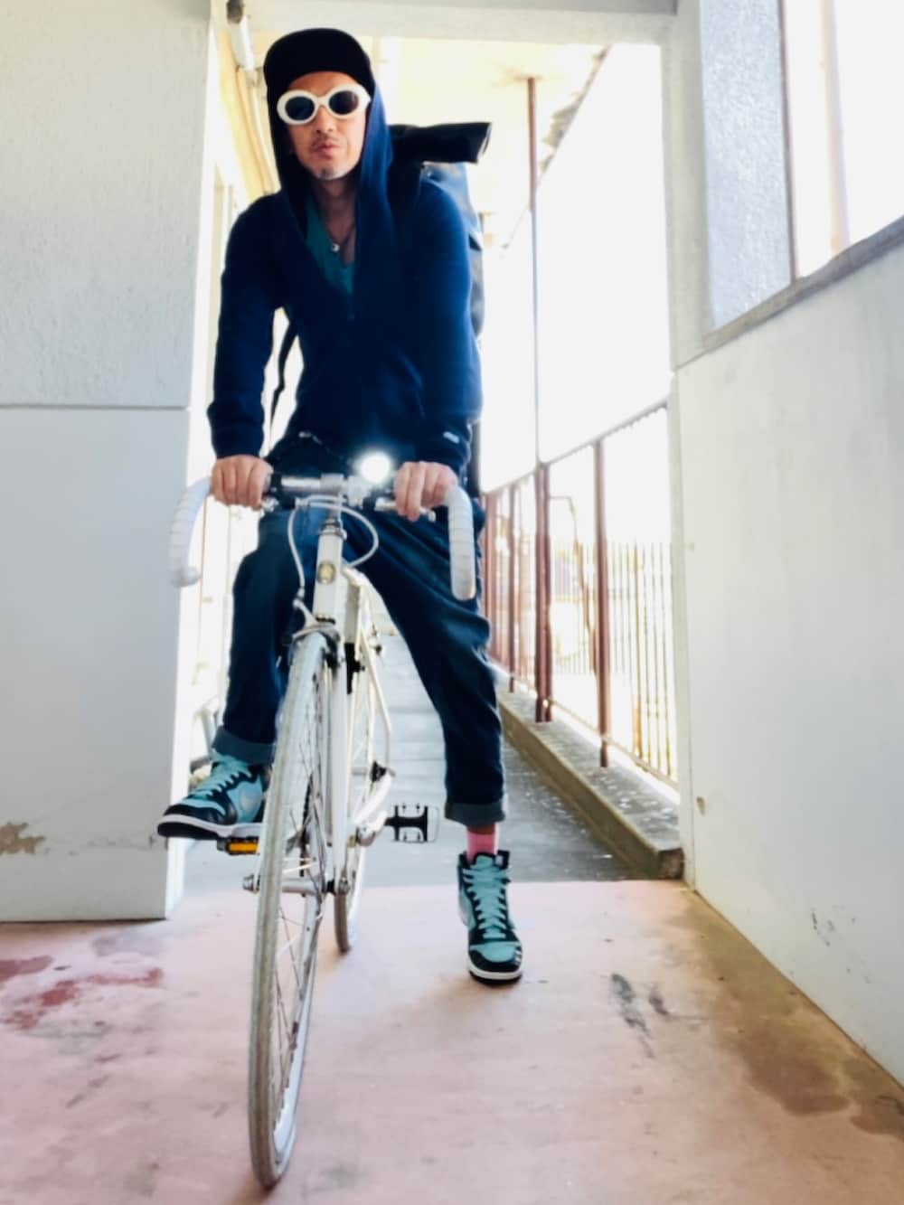 ブルー系のパーカー、ブラック系のバックパック/リュック、ブルー系のデニムパンツを着用したメンズの秋コーディネートの2枚目の写真