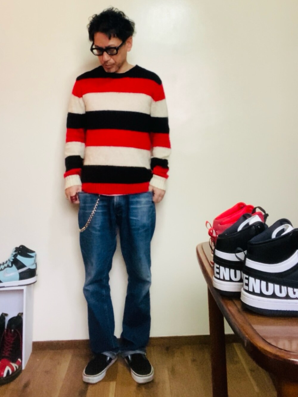 レッド系のニット/セーター、ブルー系のデニムパンツ、ブラック系のスリッポンを着用したメンズの春コーディネートの3枚目の写真