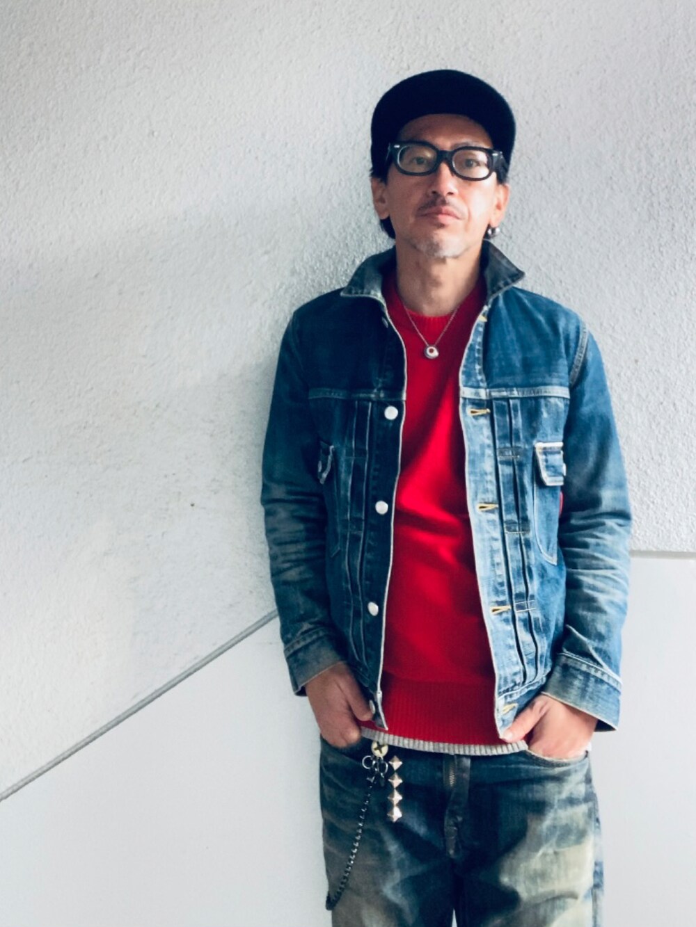 ブルー系のデニムジャケット、レッド系のニット/セーター、ブルー系のデニムパンツを着用したメンズの冬コーディネートの5枚目の写真