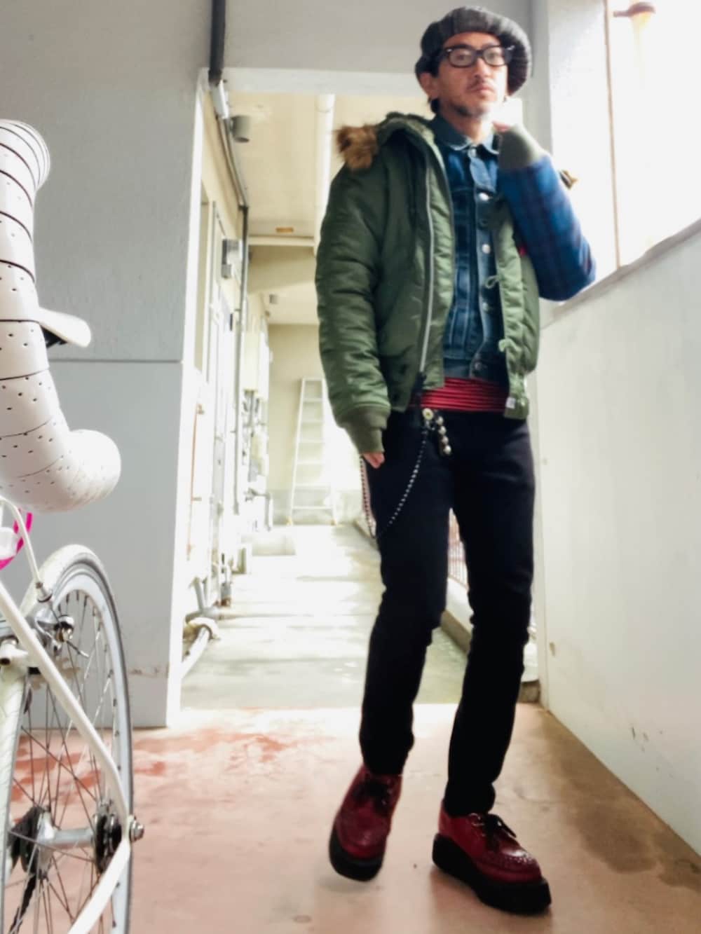 グリーン系のMA-1、ブルー系のデニムジャケット、ブラック系のパンツを着用したメンズの冬コーディネートの4枚目の写真