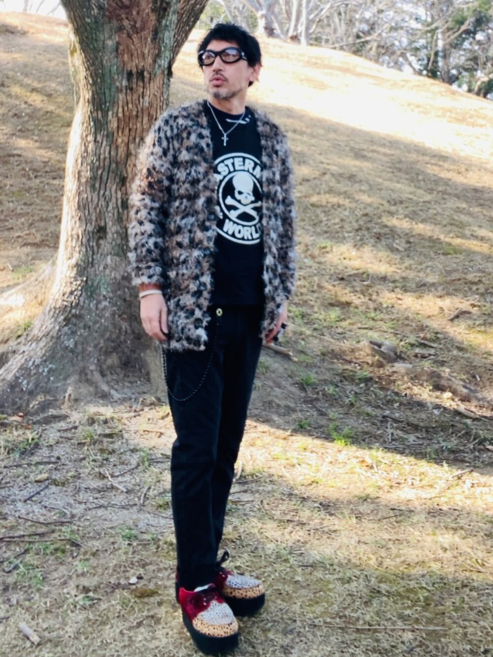ブラウン系のカーディガン/ボレロ、ブラック系のTシャツ/カットソー、ブラック系のデニムパンツを着用したメンズの春コーディネートの5枚目の写真