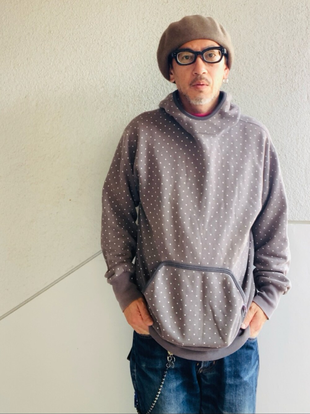 グレー系のパーカー、ブルー系のデニムパンツ、グリーン系のスニーカーを着用したメンズの春コーディネートの2枚目の写真