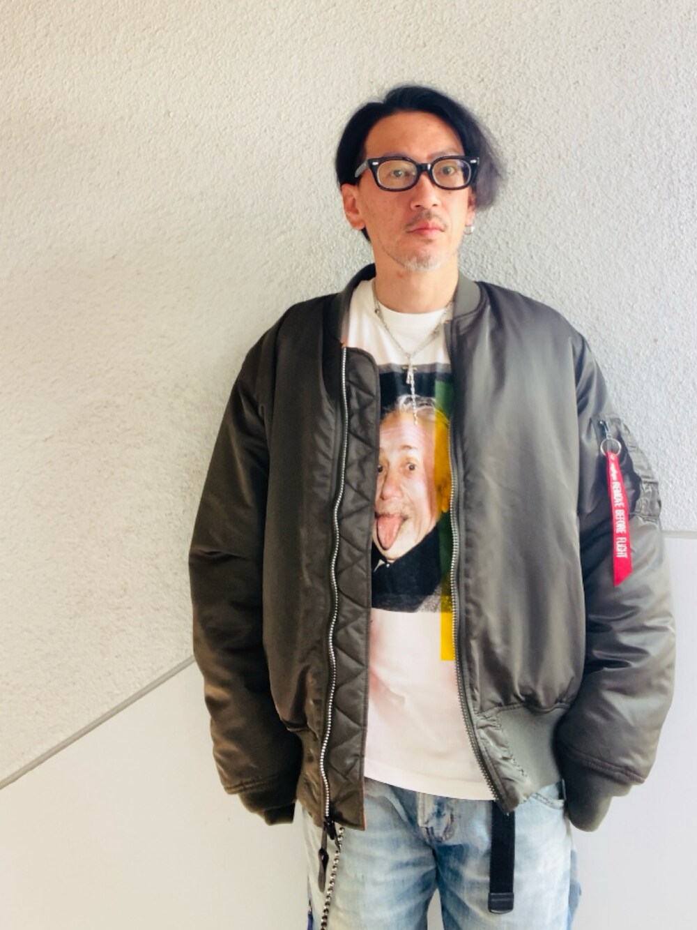 グレー系のMA-1、ホワイト系のTシャツ/カットソー、ブルー系のデニムパンツを着用したメンズの春コーディネートの2枚目の写真