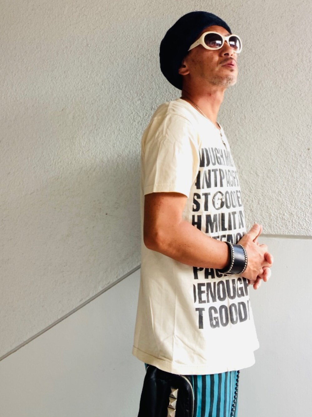 ベージュ系のTシャツ/カットソー、ブルー系のその他パンツ、ホワイト系のその他シューズを着用したメンズの夏コーディネートの4枚目の写真