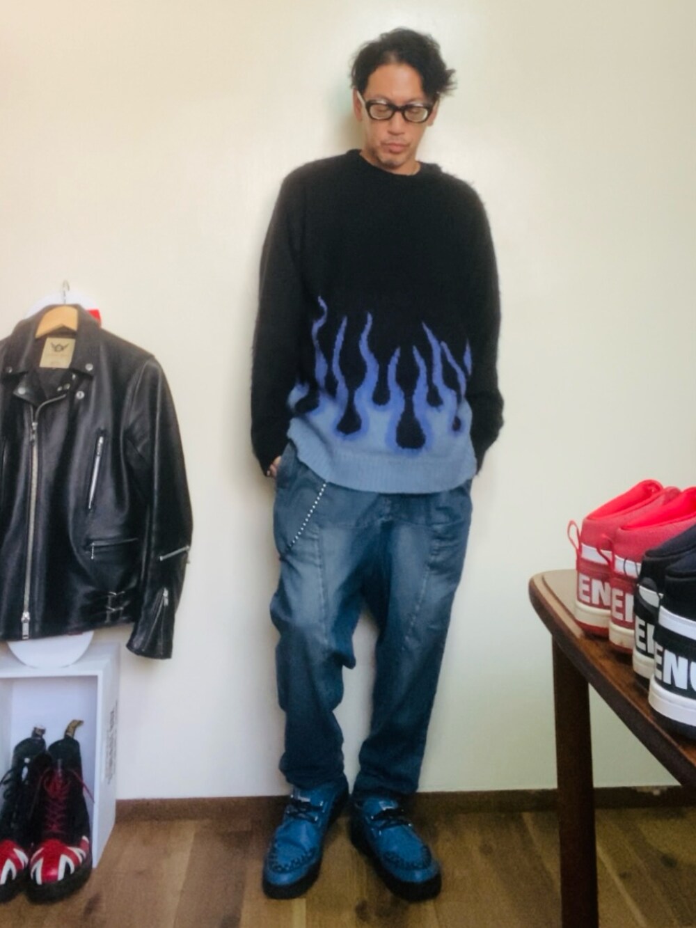 ブラック系のニット/セーター、ブルー系のデニムパンツ、ブルー系のブーツを着用したメンズの秋コーディネートの4枚目の写真