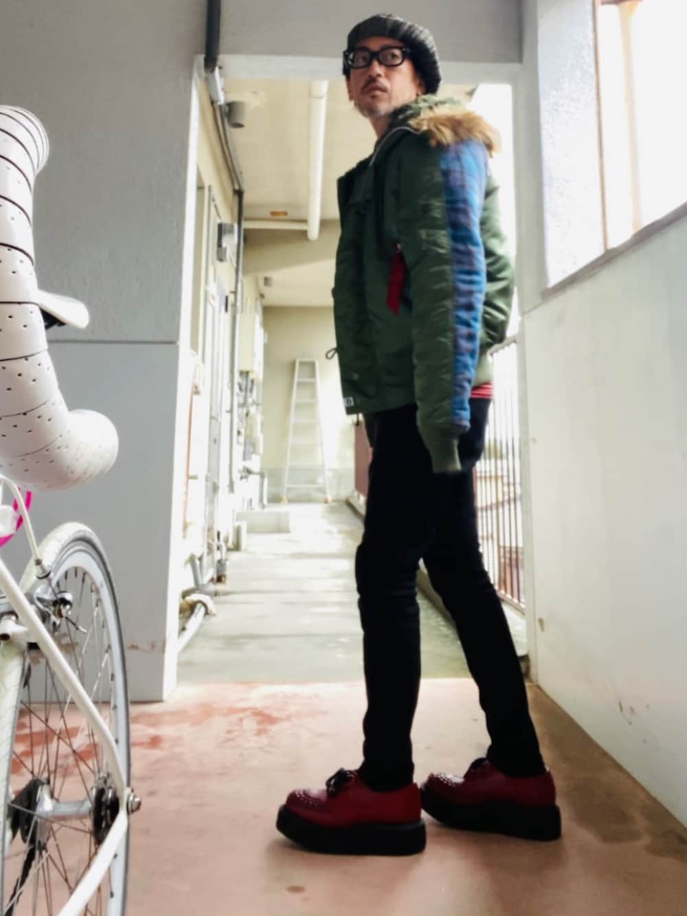 グリーン系のMA-1、ブルー系のデニムジャケット、ブラック系のパンツを着用したメンズの冬コーディネートの5枚目の写真