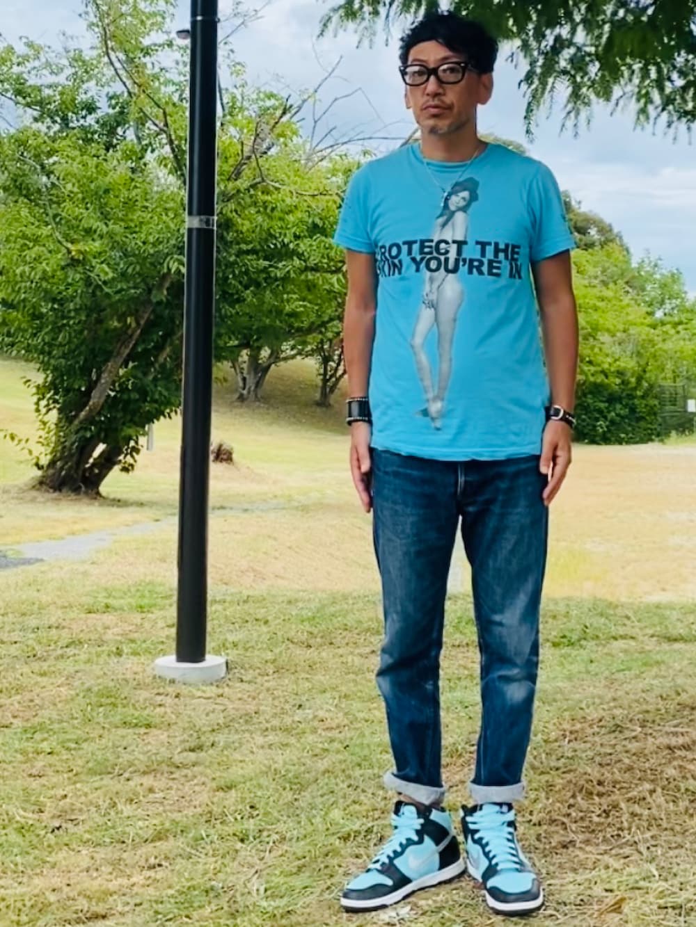 ブルー系のTシャツ/カットソー、ブルー系のデニムパンツ、グリーン系のスニーカーを着用したメンズの夏コーディネートの5枚目の写真