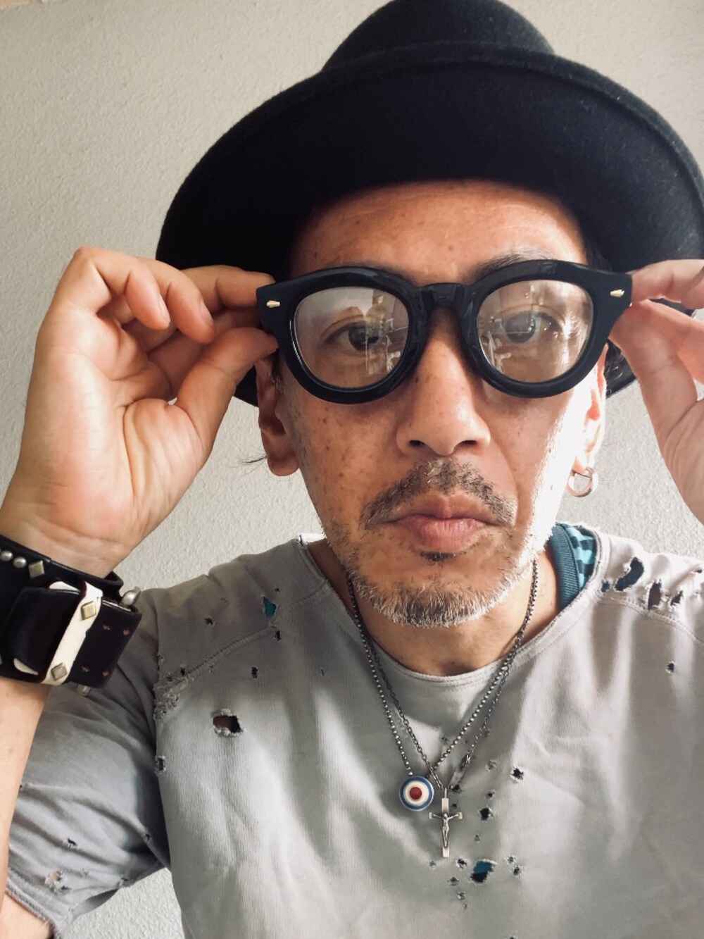 グレー系のTシャツ/カットソー、ブルー系のタンクトップ、ブラック系のデニムパンツを着用したメンズの秋コーディネートの5枚目の写真