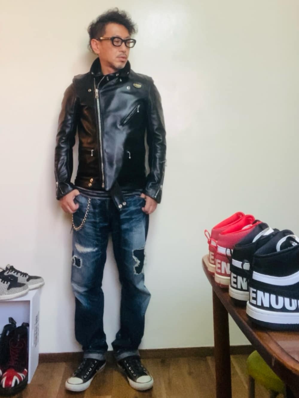 ブラック系のライダースジャケット、ブルー系のデニムパンツ、ブラック系のスニーカーを着用したメンズの秋コーディネートの2枚目の写真