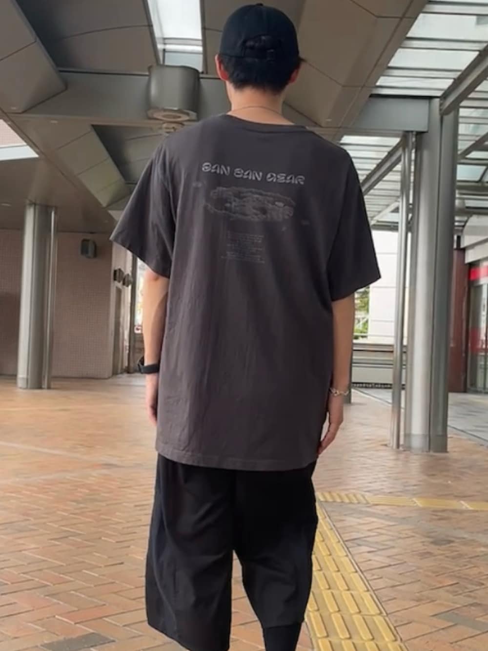 グレー系のTシャツ/カットソー、ブラック系のその他パンツ、ブラック系のスニーカーを着用したメンズの秋コーディネートの2枚目の写真