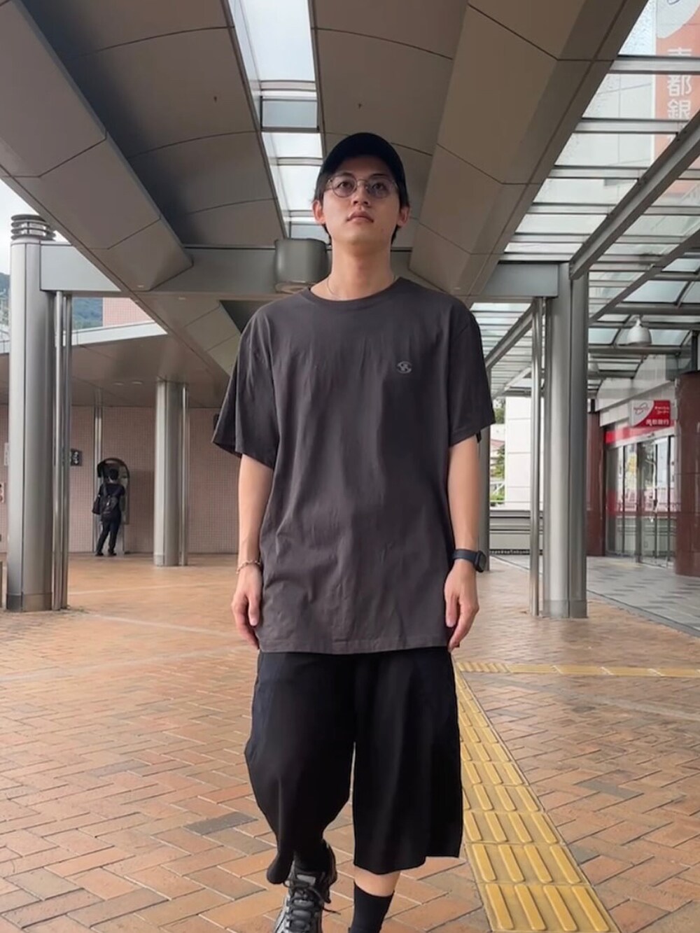 グレー系のTシャツ/カットソー、ブラック系のその他パンツ、ブラック系のスニーカーを着用したメンズの秋コーディネートの5枚目の写真