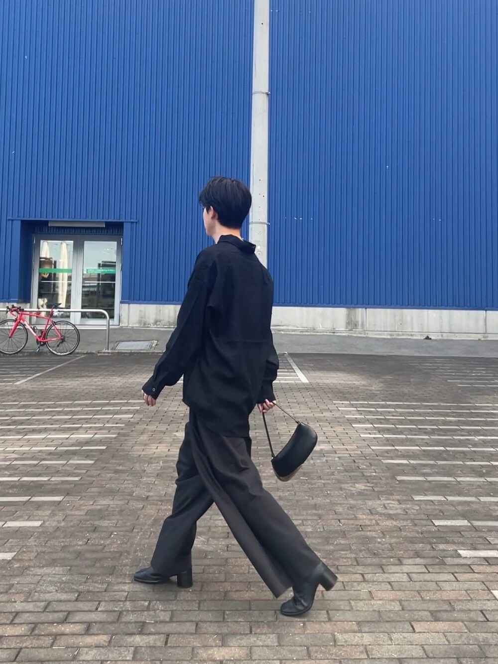 ブルー系のシャツ/ブラウス、グレー系のニット/セーター、ブラック系のチノパンツを着用したメンズの秋コーディネートの2枚目の写真