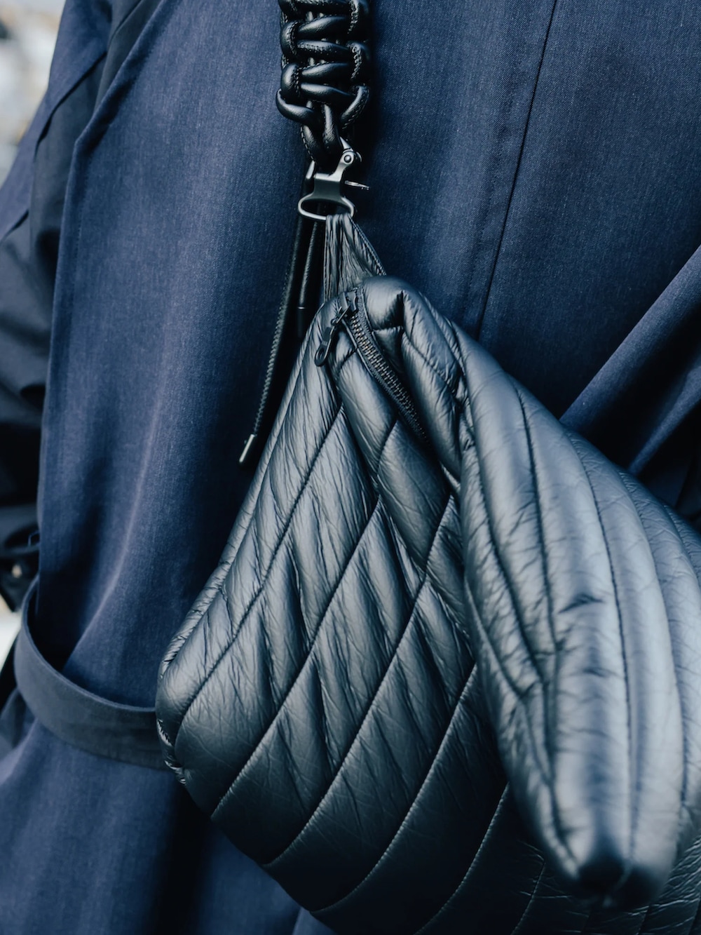 ブルー系のステンカラーコート、ベージュ系のニット/セーター、ブラック系のその他パンツを着用したメンズの夏コーディネートの3枚目の写真