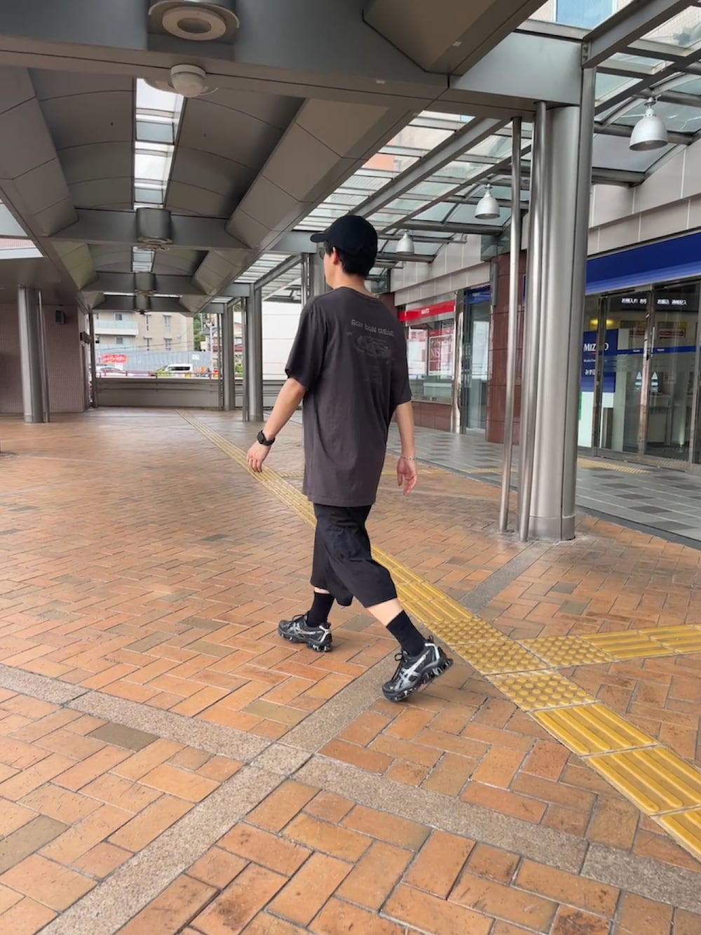 グレー系のTシャツ/カットソー、ブラック系のその他パンツ、ブラック系のスニーカーを着用したメンズの秋コーディネートの4枚目の写真
