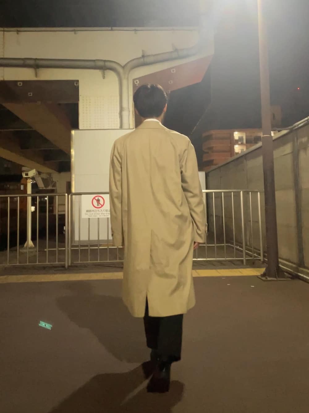 ホワイト系のビジネスシャツ、ベージュ系のステンカラーコート、ブルー系のスラックスを着用したメンズの秋コーディネートの2枚目の写真