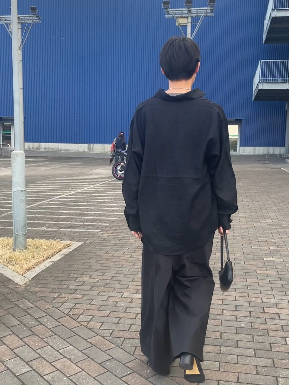 ブルー系のシャツ/ブラウス、グレー系のニット/セーター、ブラック系のチノパンツを着用したメンズの秋コーディネートの3枚目の写真