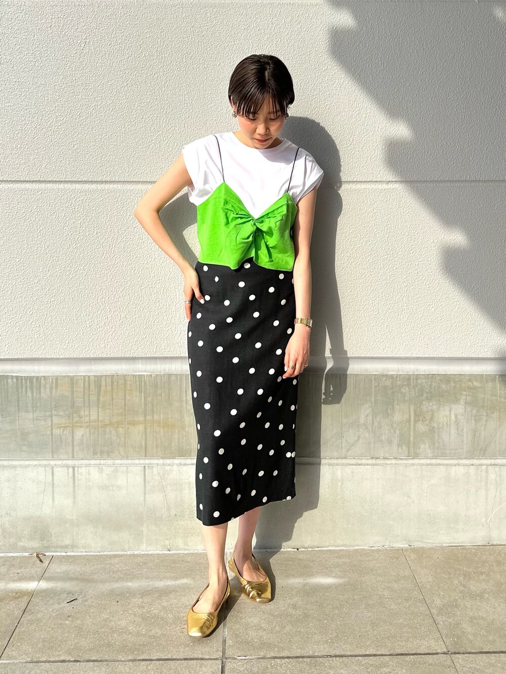 グリーン系のTシャツ/カットソー、ブラック系のスカートを着用したレディースの夏コーディネートの2枚目の写真