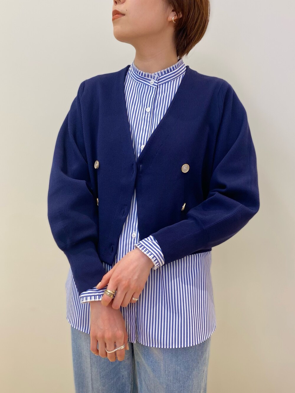 ホワイト系のショルダーバッグ、ブルー系のカーディガン/ボレロ、ブルー系のシャツ/ブラウスを着用したレディースの冬コーディネートの4枚目の写真