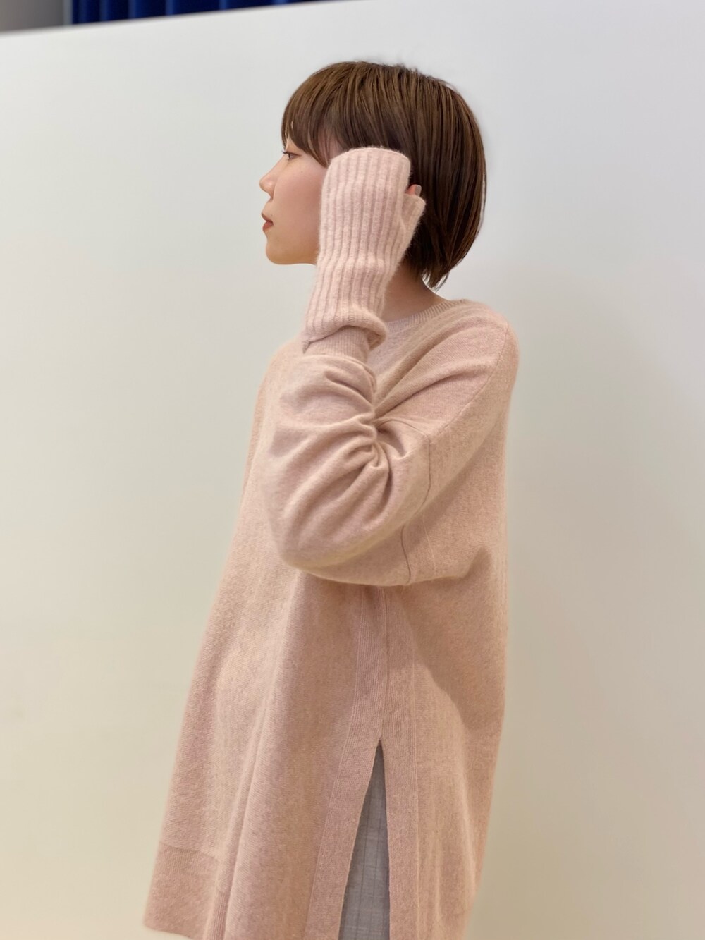 ベージュ系のブーツ、ピンク系のニット/セーター、グレー系のスカートを着用したレディースの冬コーディネートの3枚目の写真