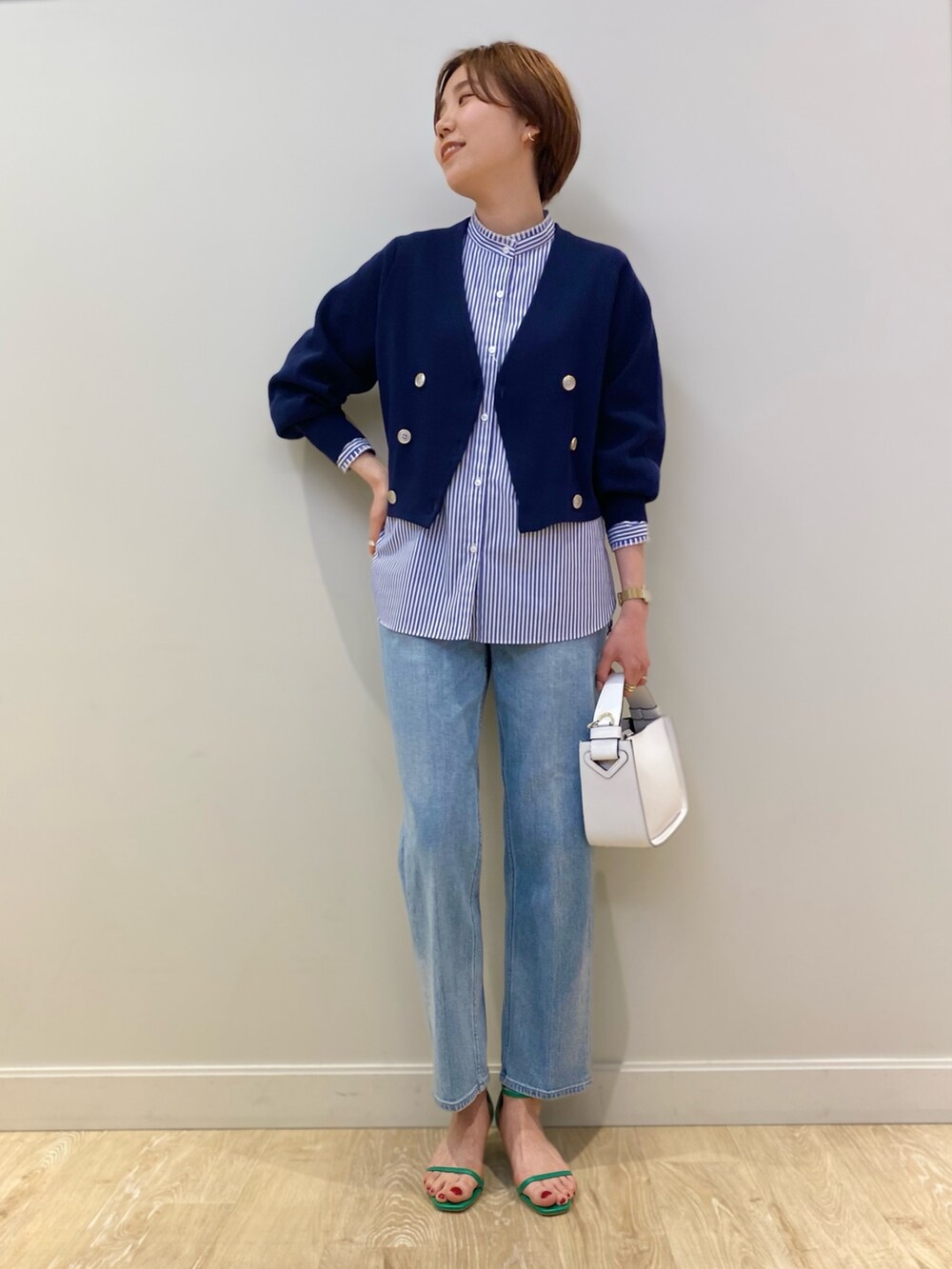 ホワイト系のショルダーバッグ、ブルー系のカーディガン/ボレロ、ブルー系のシャツ/ブラウスを着用したレディースの冬コーディネートの2枚目の写真