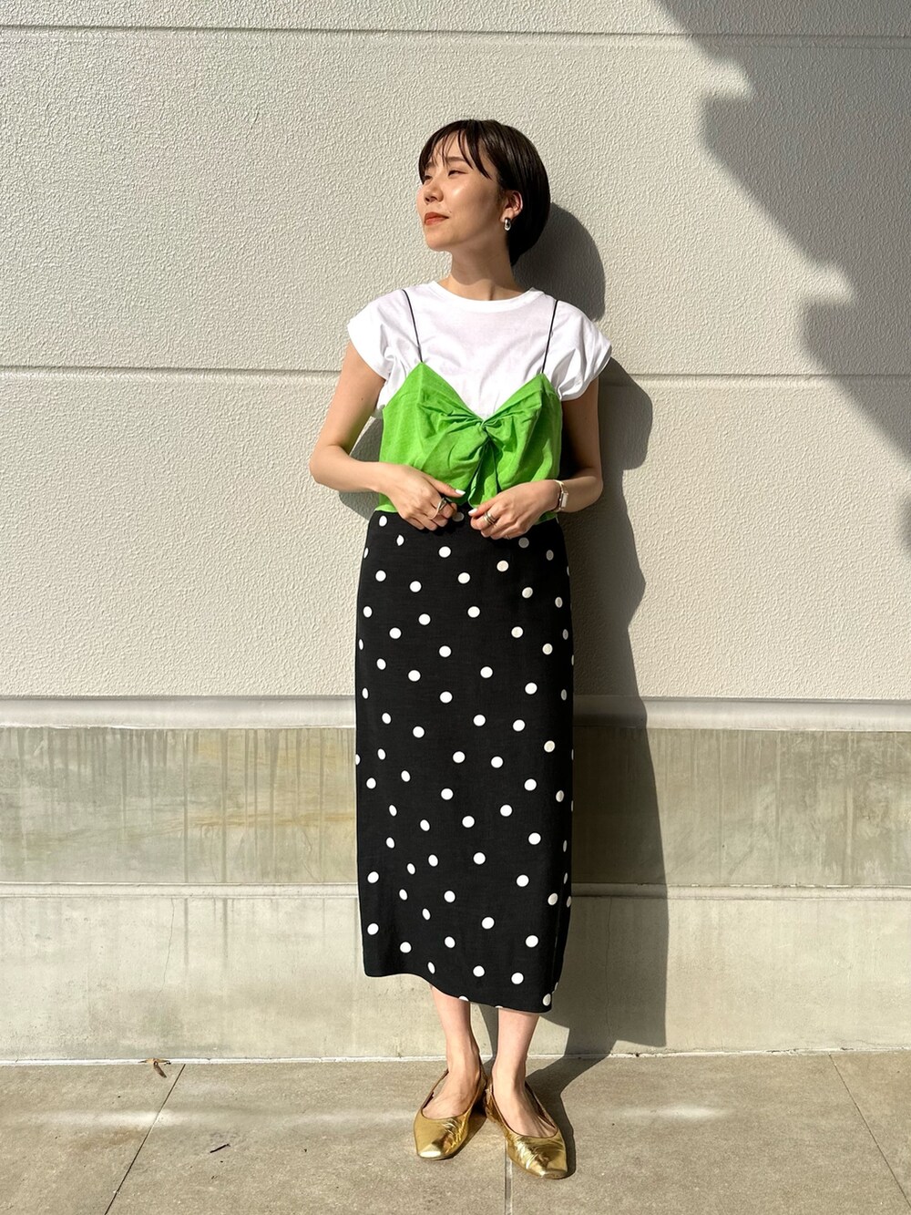 グリーン系のTシャツ/カットソー、ブラック系のスカートを着用したレディースの夏コーディネートの3枚目の写真